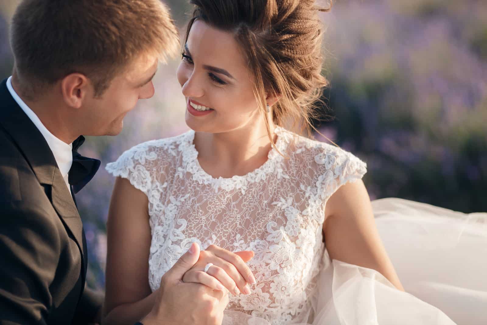 the man holds the bride by the arms