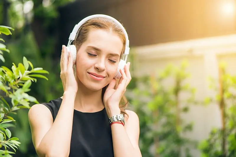 woman listening to music on headphones with eyes closed