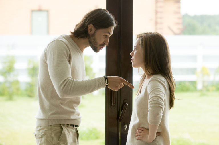 man pointing at woman while speaking