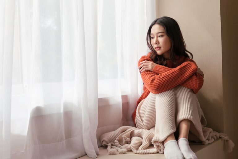 sad woman sitting by the window