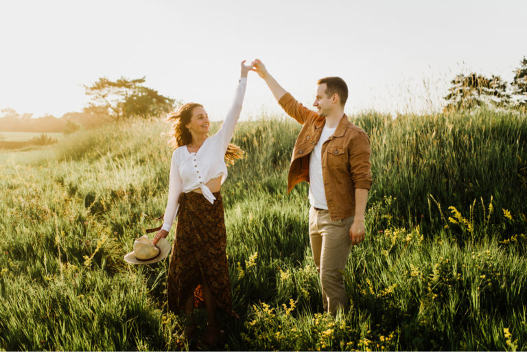 a man holds the hand of a woman in a field