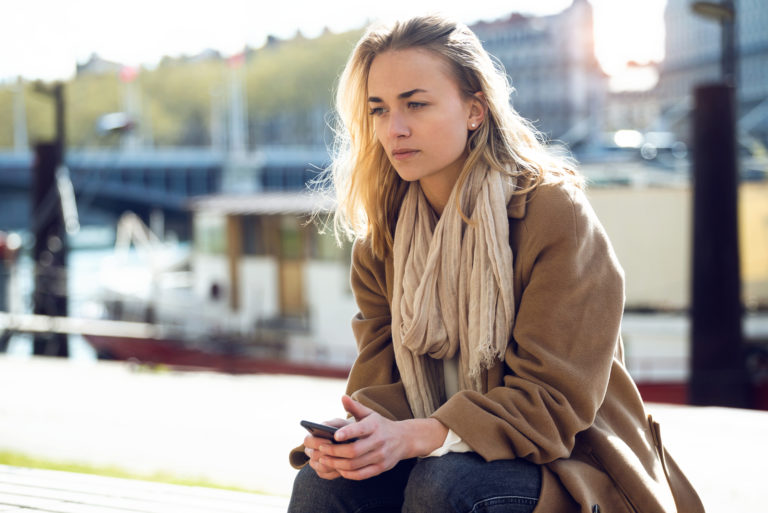 the imagined woman sits and holds the phone in her hand