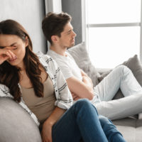 young couple after fight sitting on couch