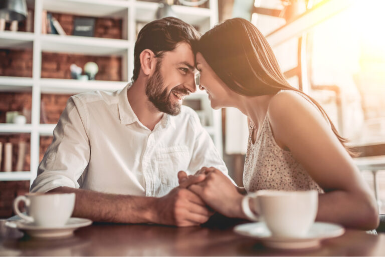 a couple in love sits at a table and cuddles