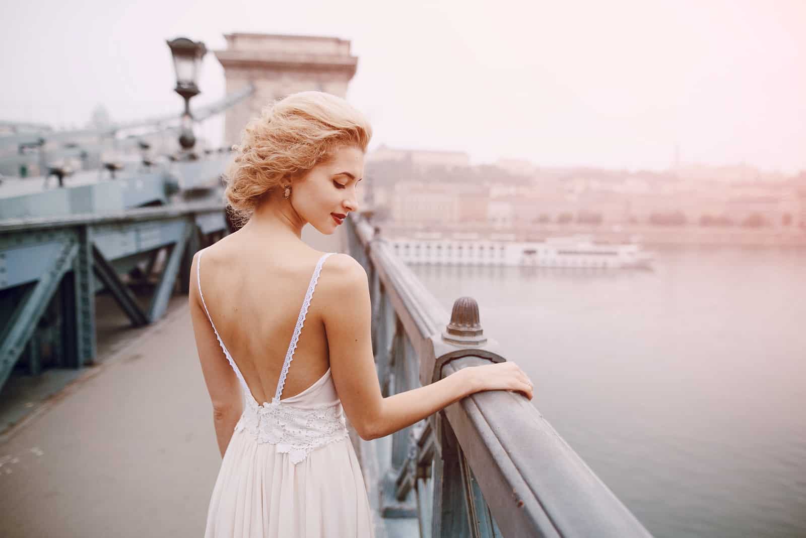 a beautiful woman in a white dress sets the bridge