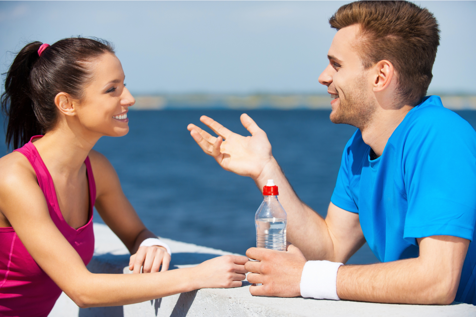 a man and a woman leaning against the wall are talking