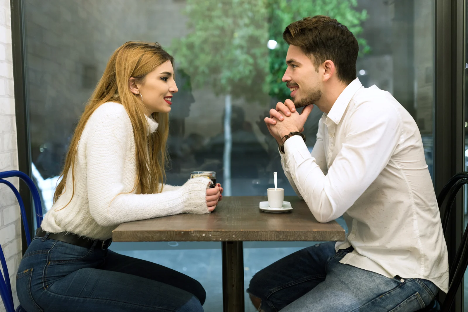 a man and a woman sit at a table and talk
