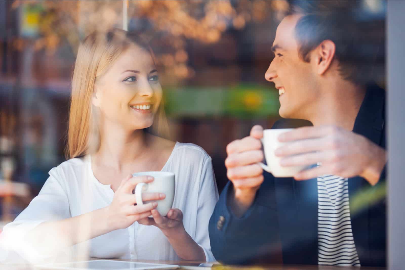 un uomo e una donna che parlano davanti a un caffè