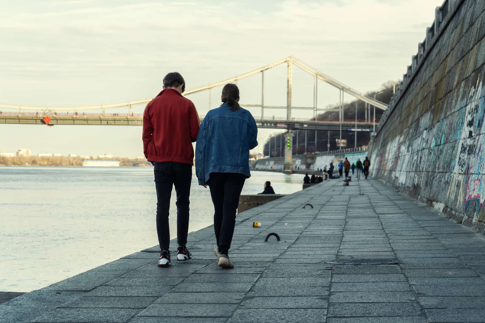 un uomo e una donna camminano lungo il fiume
