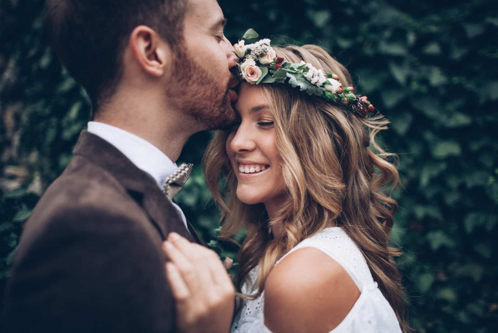 a man kisses a beautiful woman on the forehead