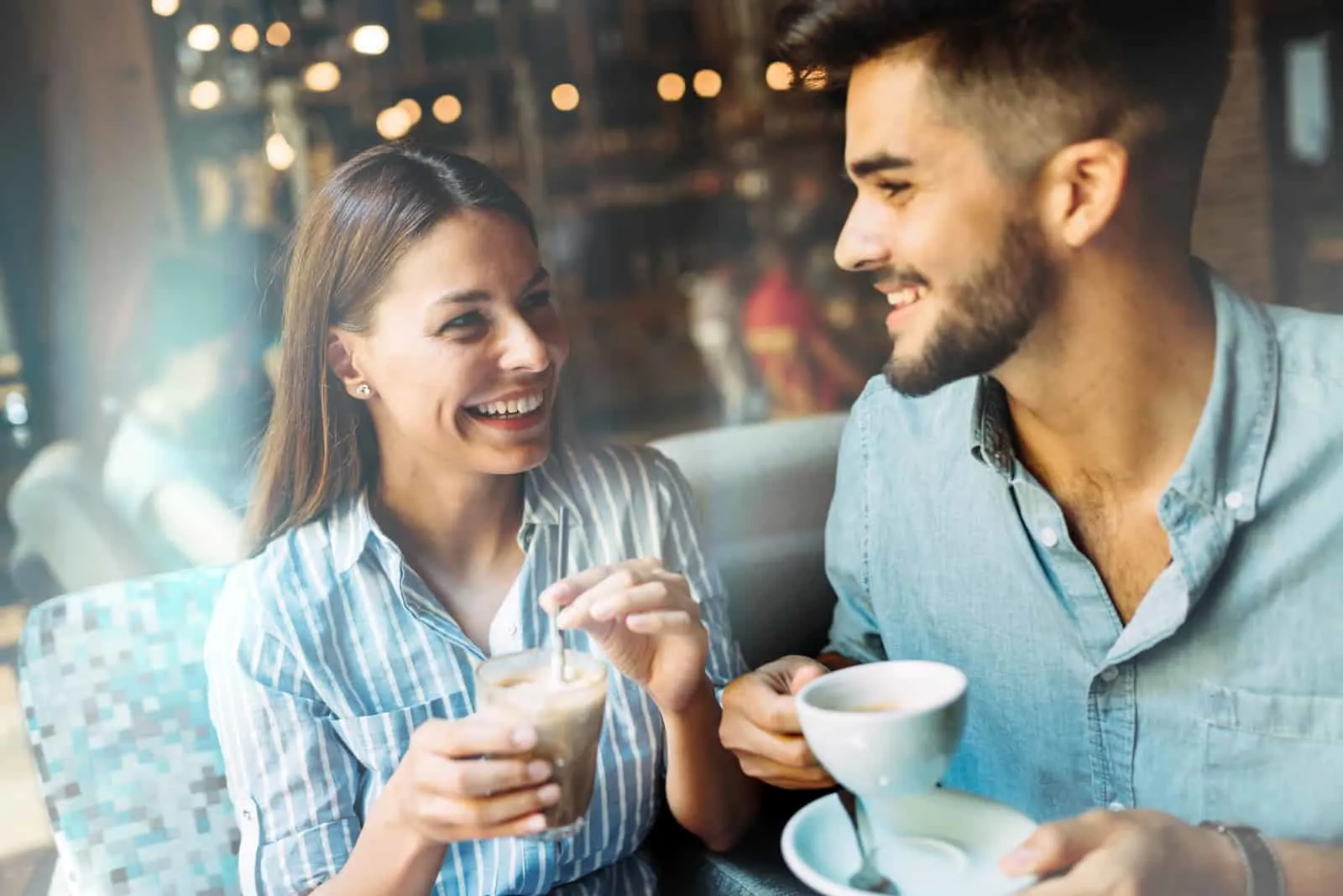a smiling man and woman drinking coffee