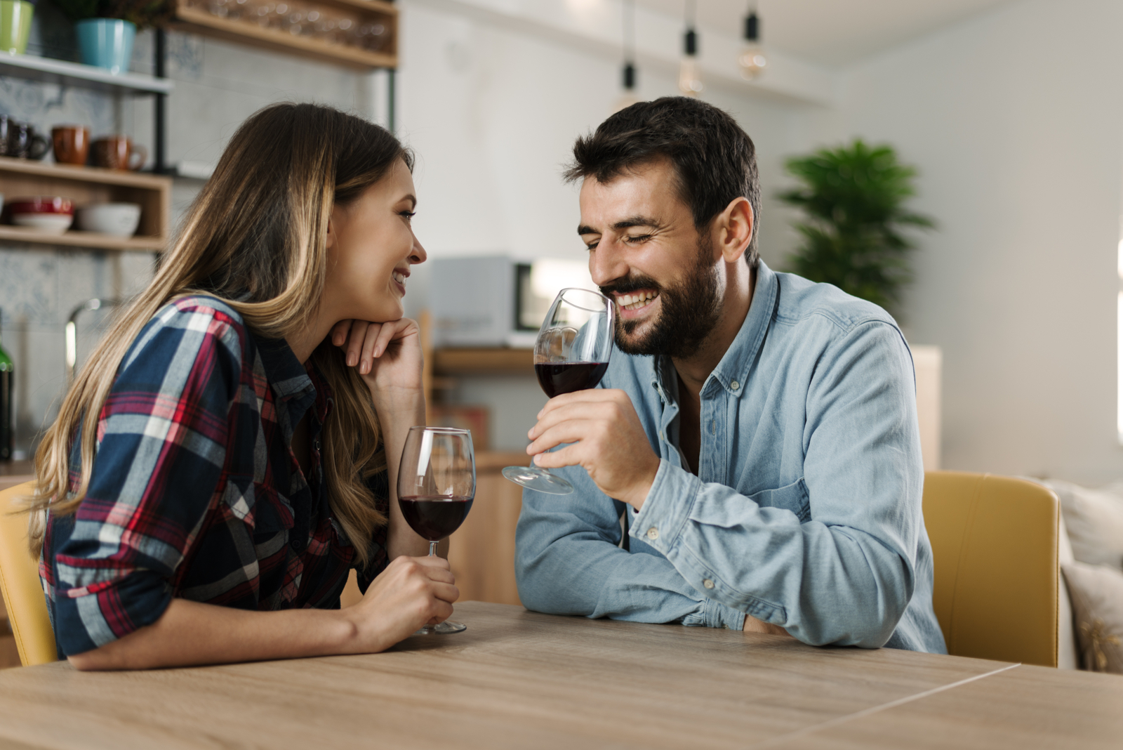 a smiling man and woman sit at a table and talk