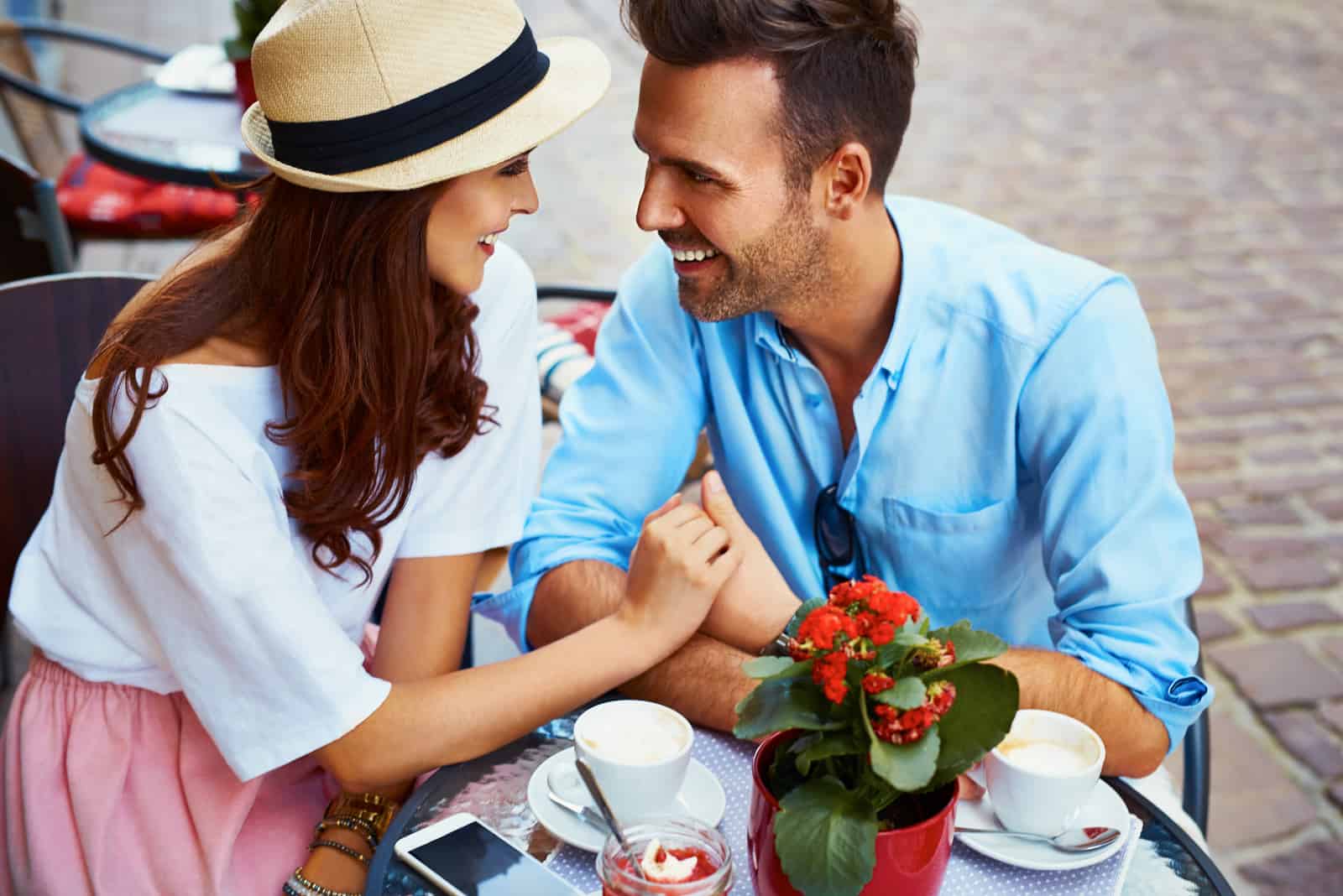 un uomo e una donna sorridenti siedono a un tavolo e parlano