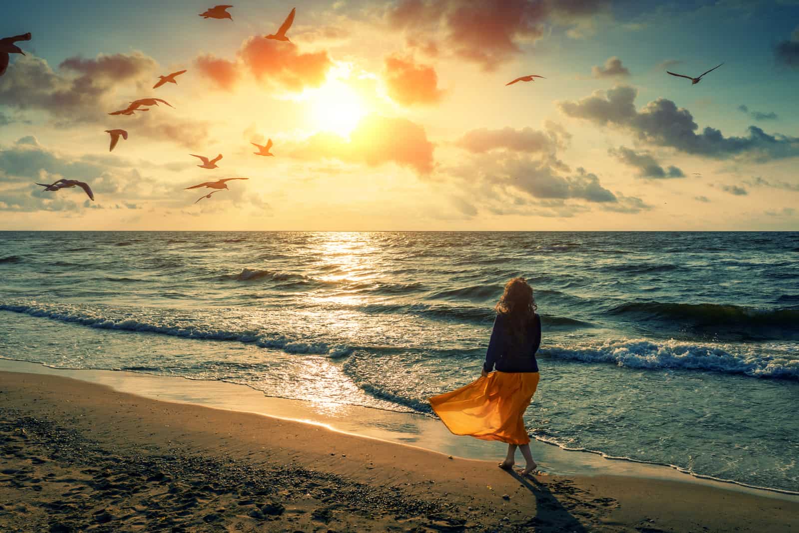 una donna al tramonto sulla spiaggia