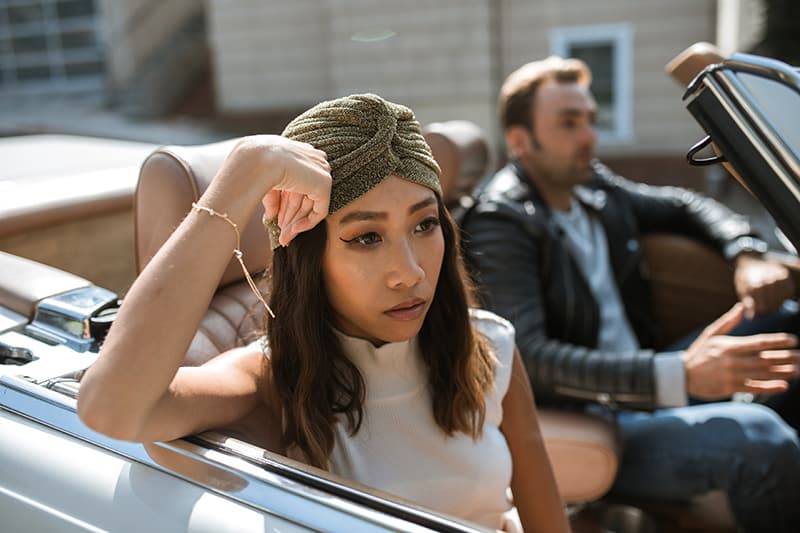 mulher irritada sentada no carro com um homem