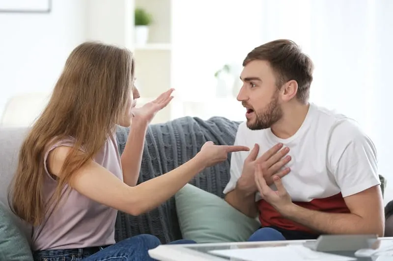 couple arguing at home sitting on the couch