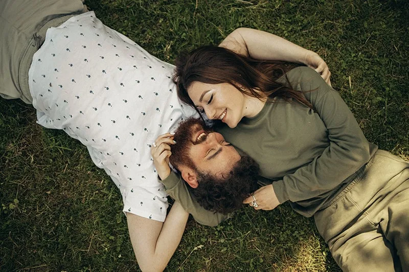 couple facing each other lying on the ground