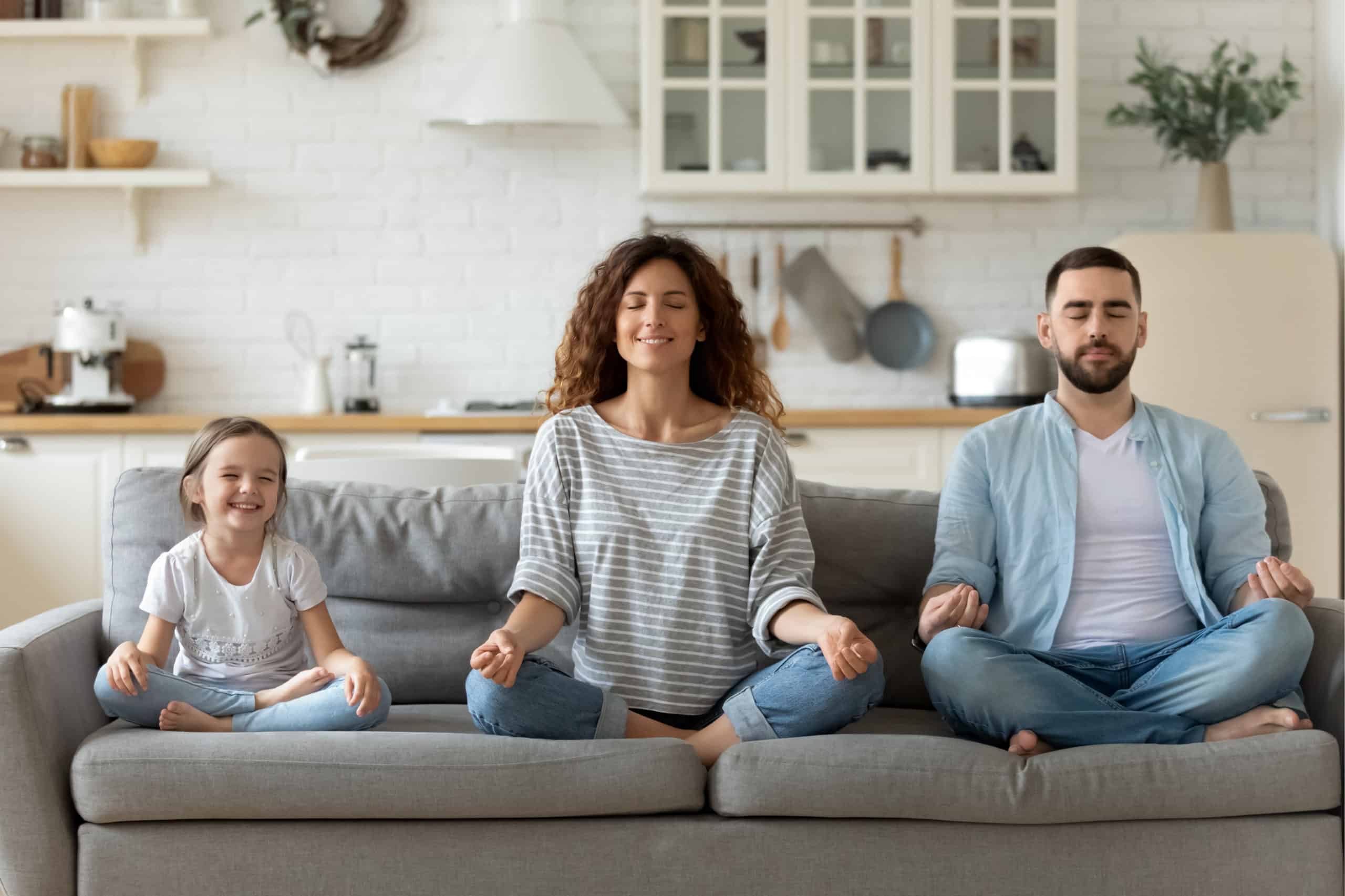 family meditating together on couch