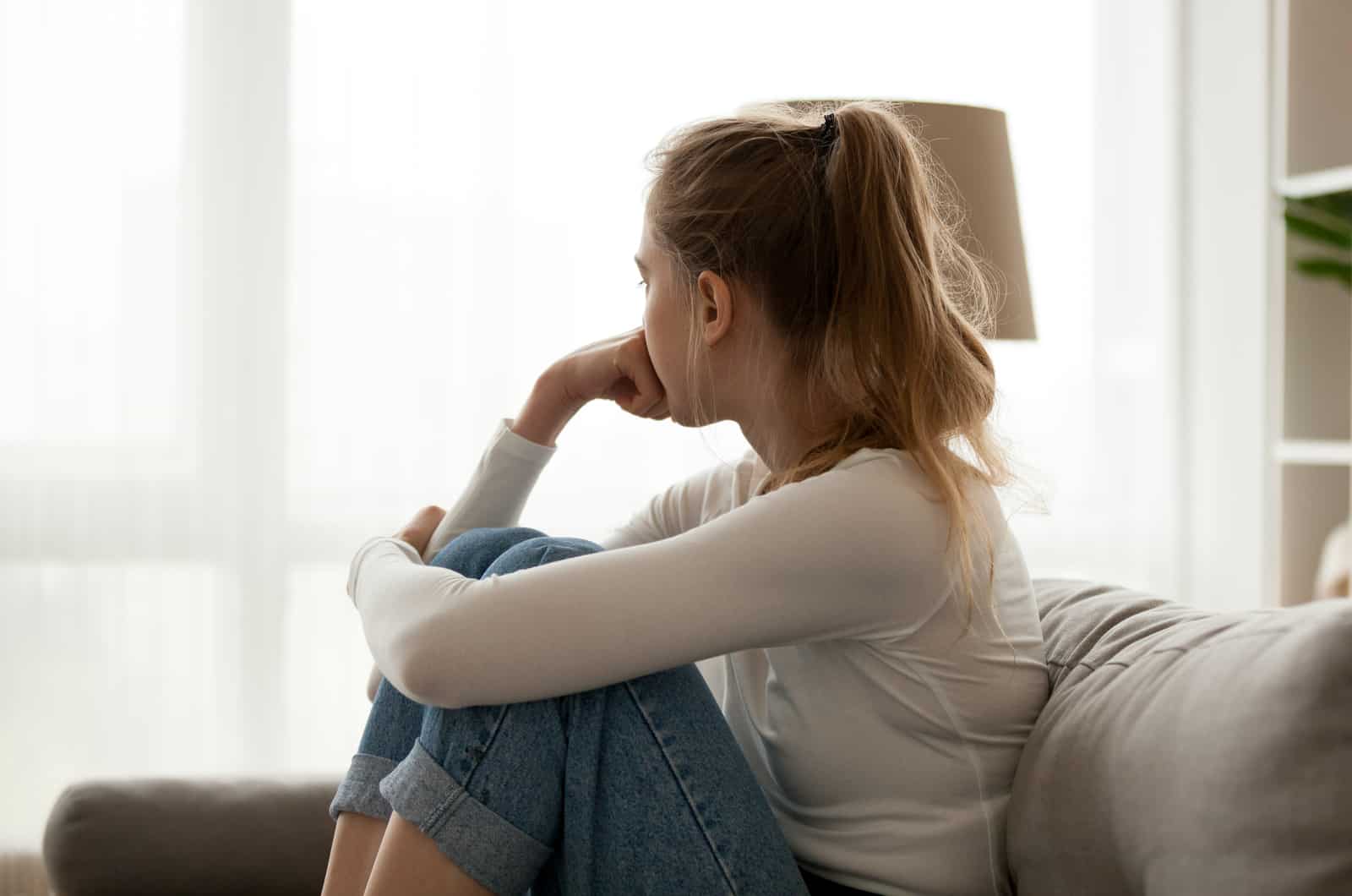girl sitting on couch looking at distance