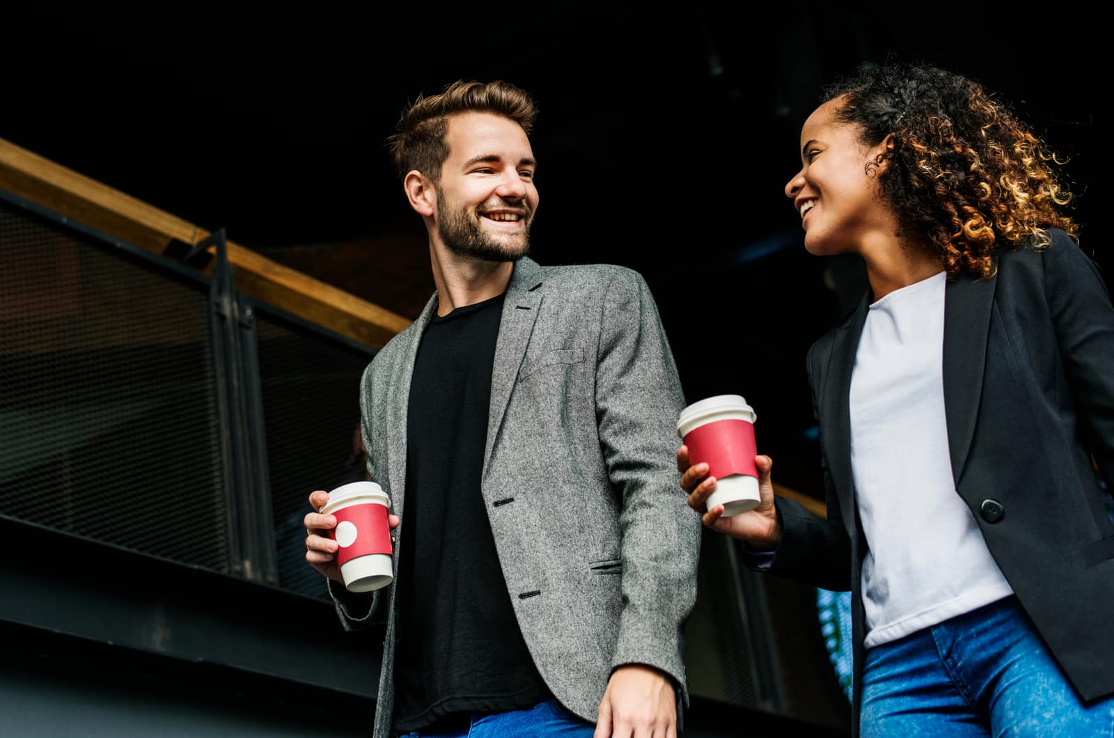 uomo e donna che camminano bevendo caffè