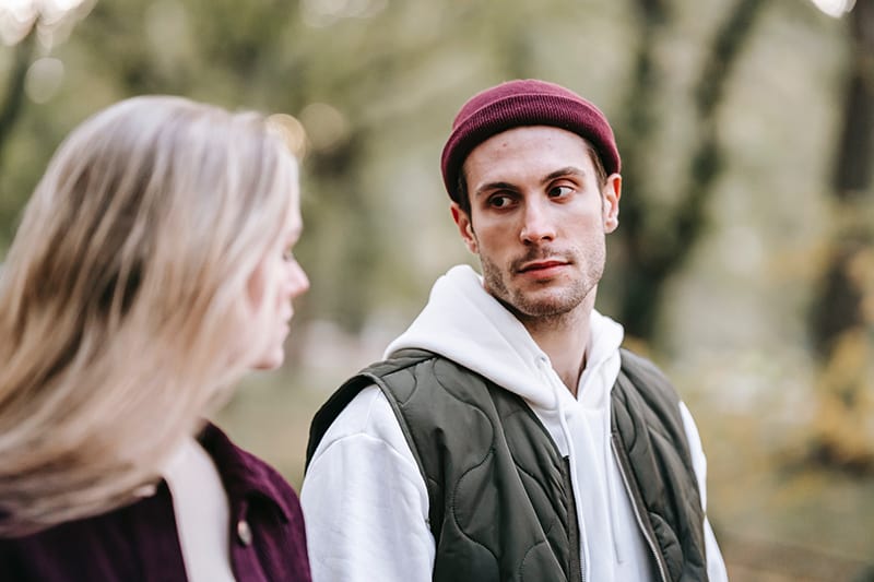 serious man looking at woman walking with him