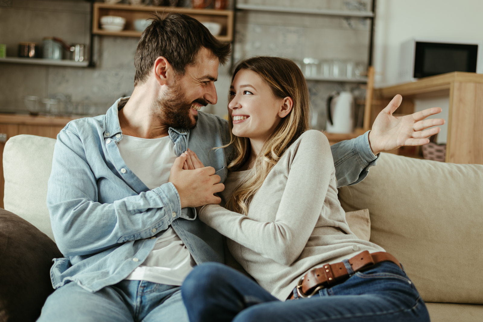 the man hugged the woman and sat on the couch