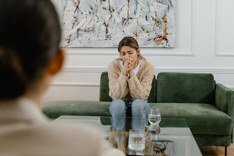 upset woman sitting on the couch at therapist