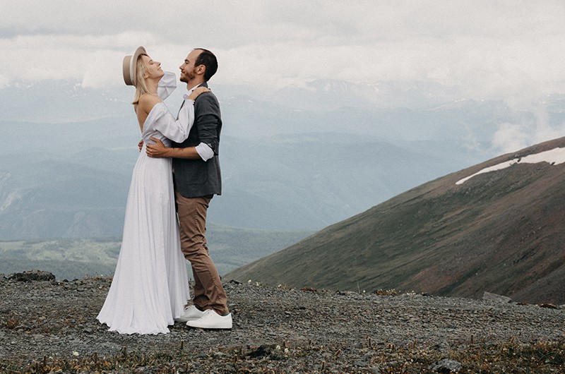 coppia di sposi che si abbraccia in piedi in montagna