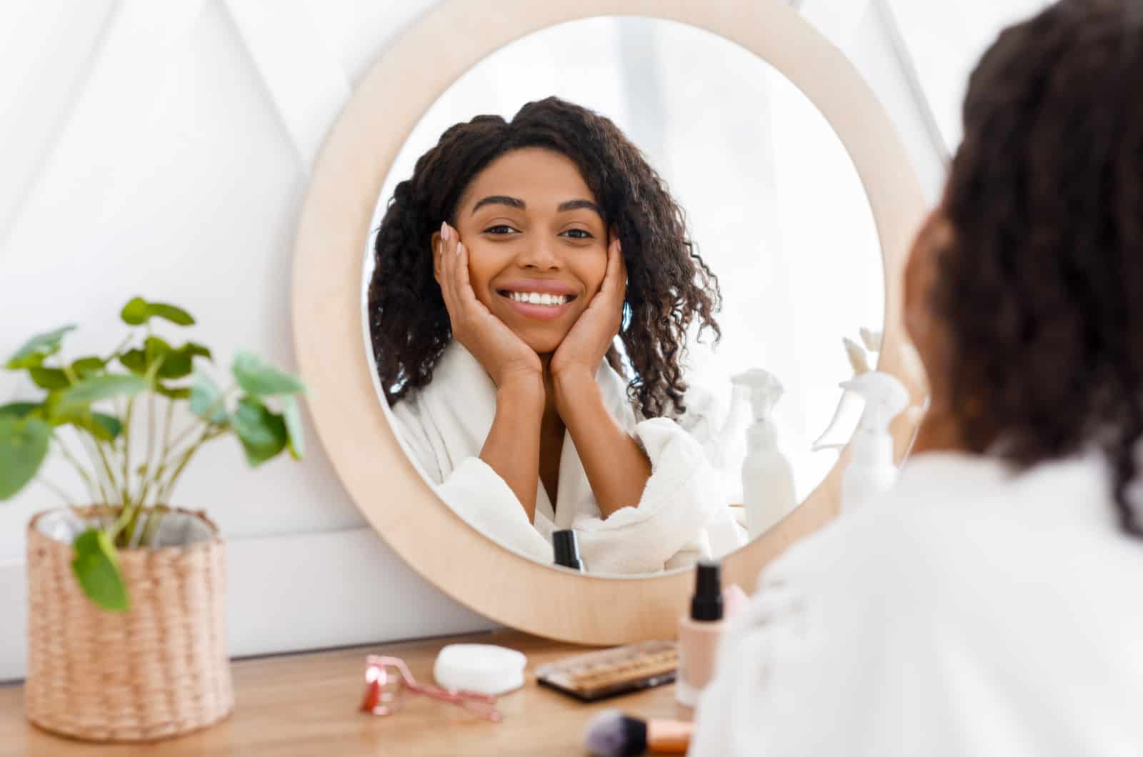 woman looking at mirror while doing skincare