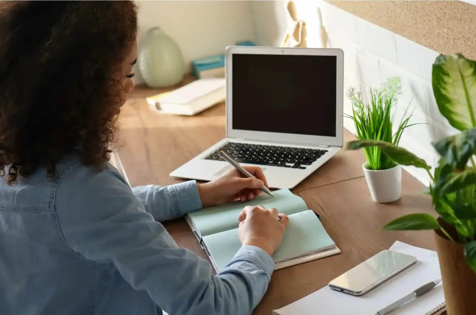woman sitting at desk writing