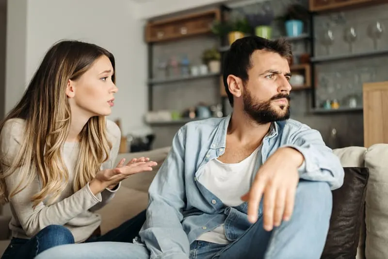 woman talking to upset boyfriend at home