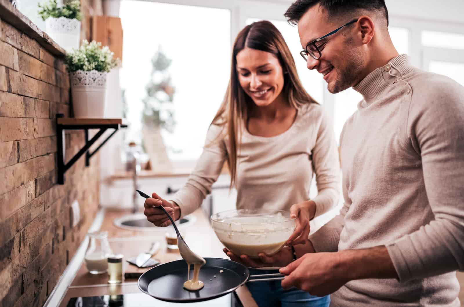 pareja joven cocinando en la cocina