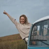 happy woman hanging from van window