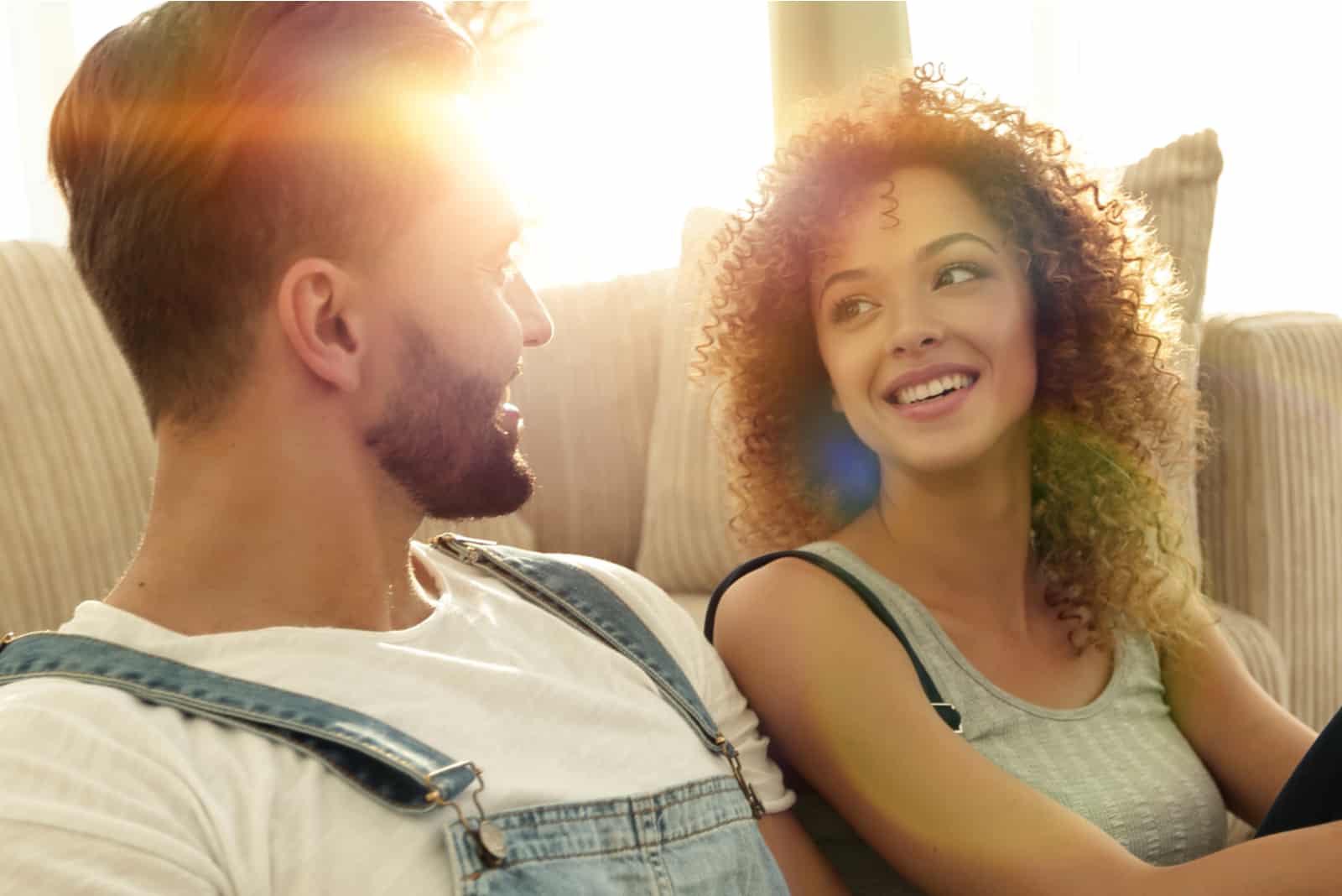 a smiling man and woman sit and talk