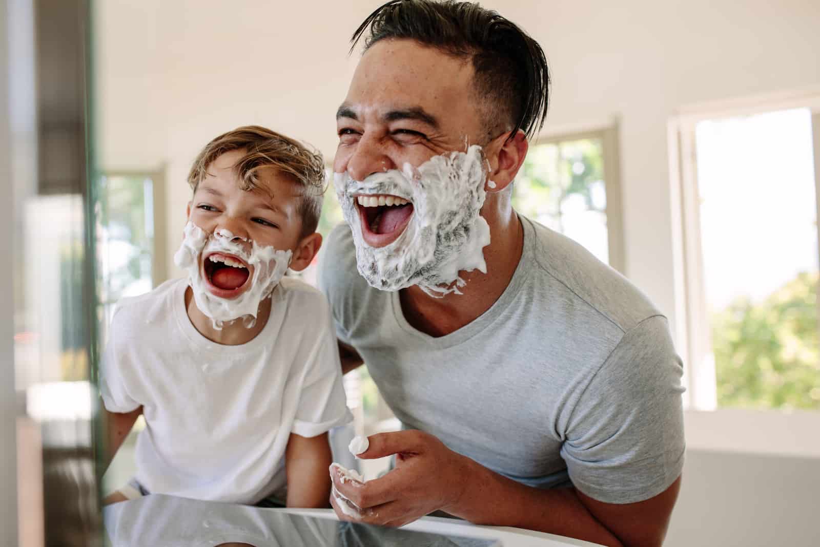 father and son in bathroom with shaving cream on face