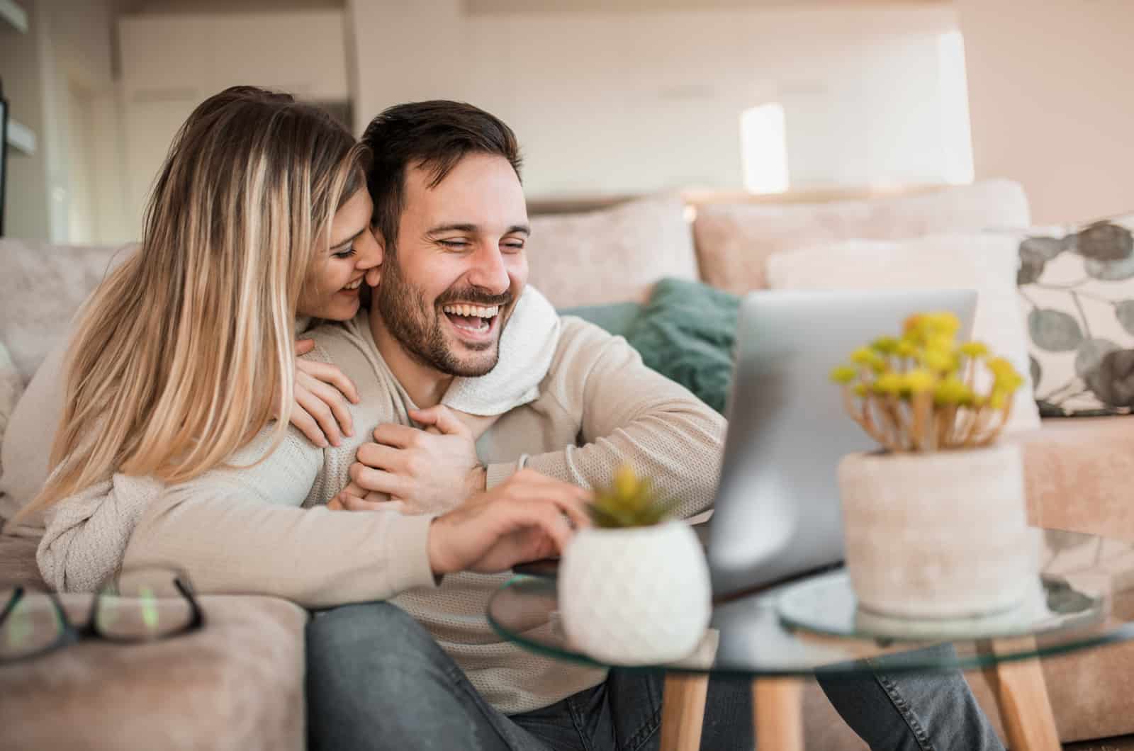 happy couple cuddling in living room