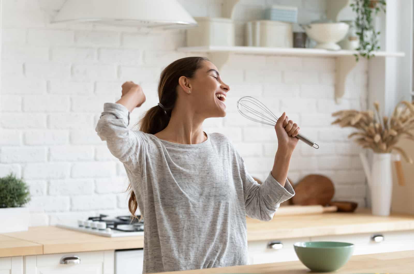 happy woman singing in kitchen