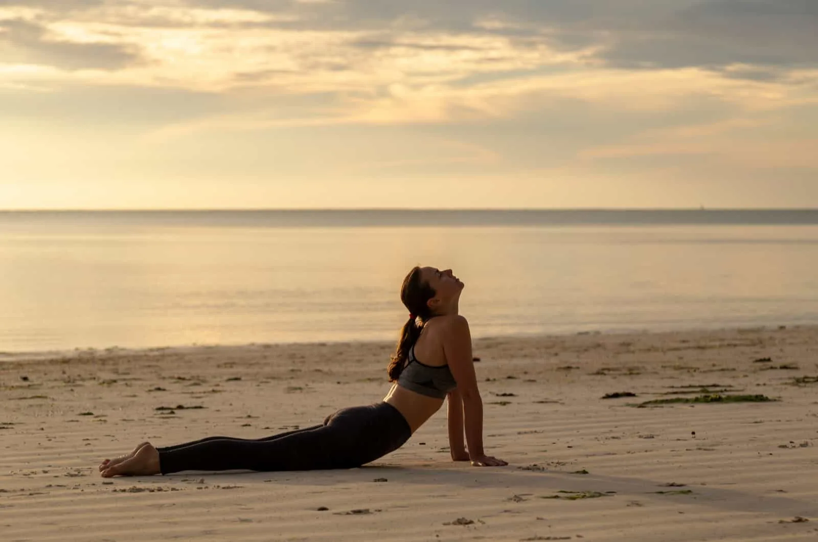woman doing yoga at beach
