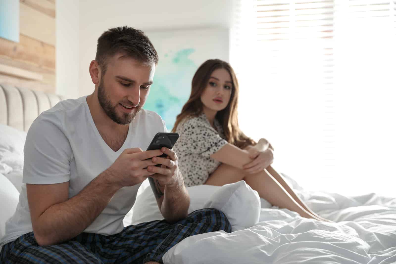 woman looking at partners phone over his shoulder