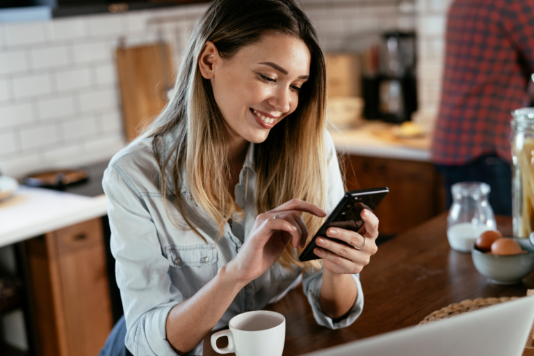 a smiling woman holding a phone in her hand