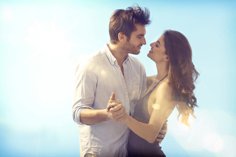 a beautiful woman with long brown hair dances with a man