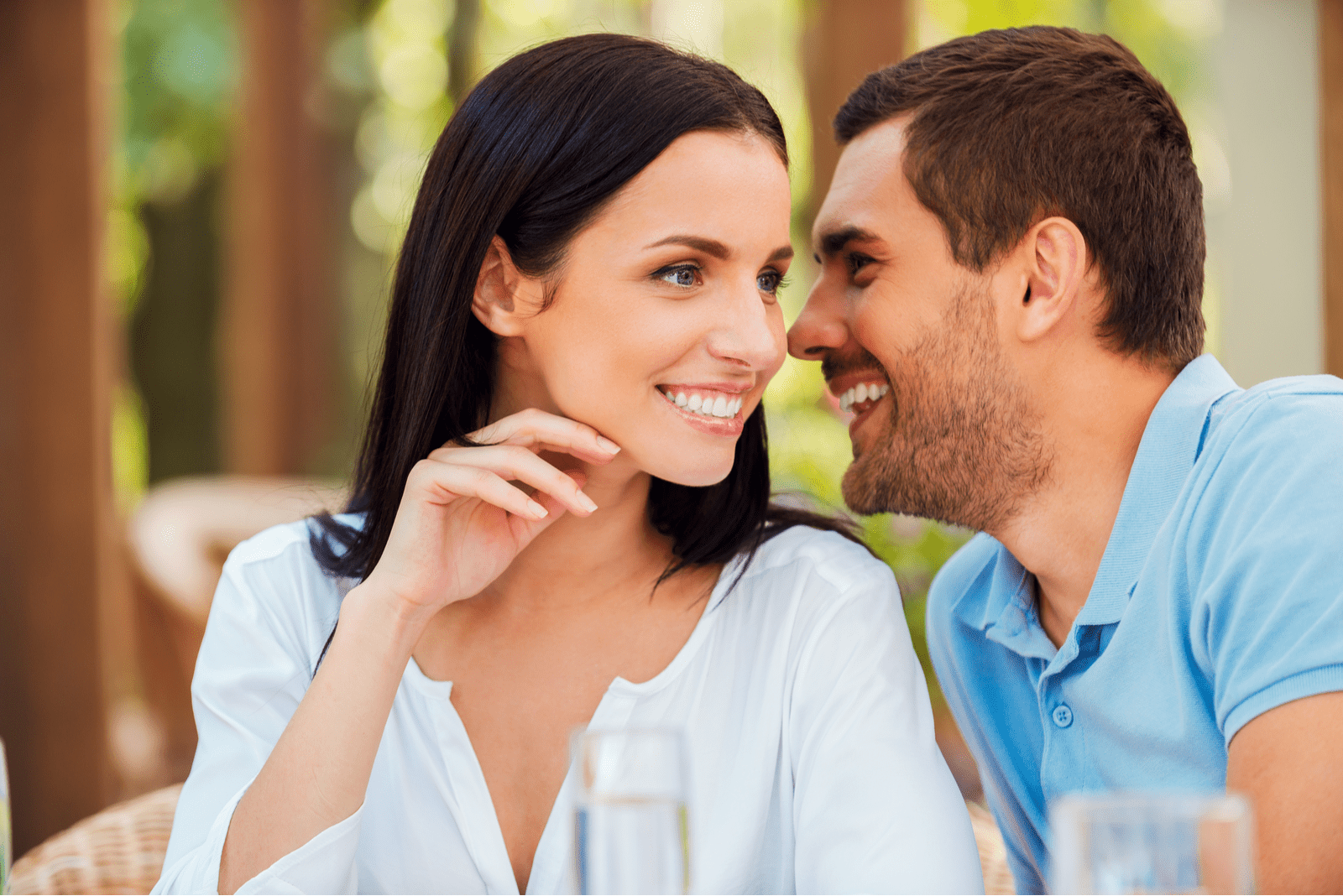 a smiling man and woman sit talking