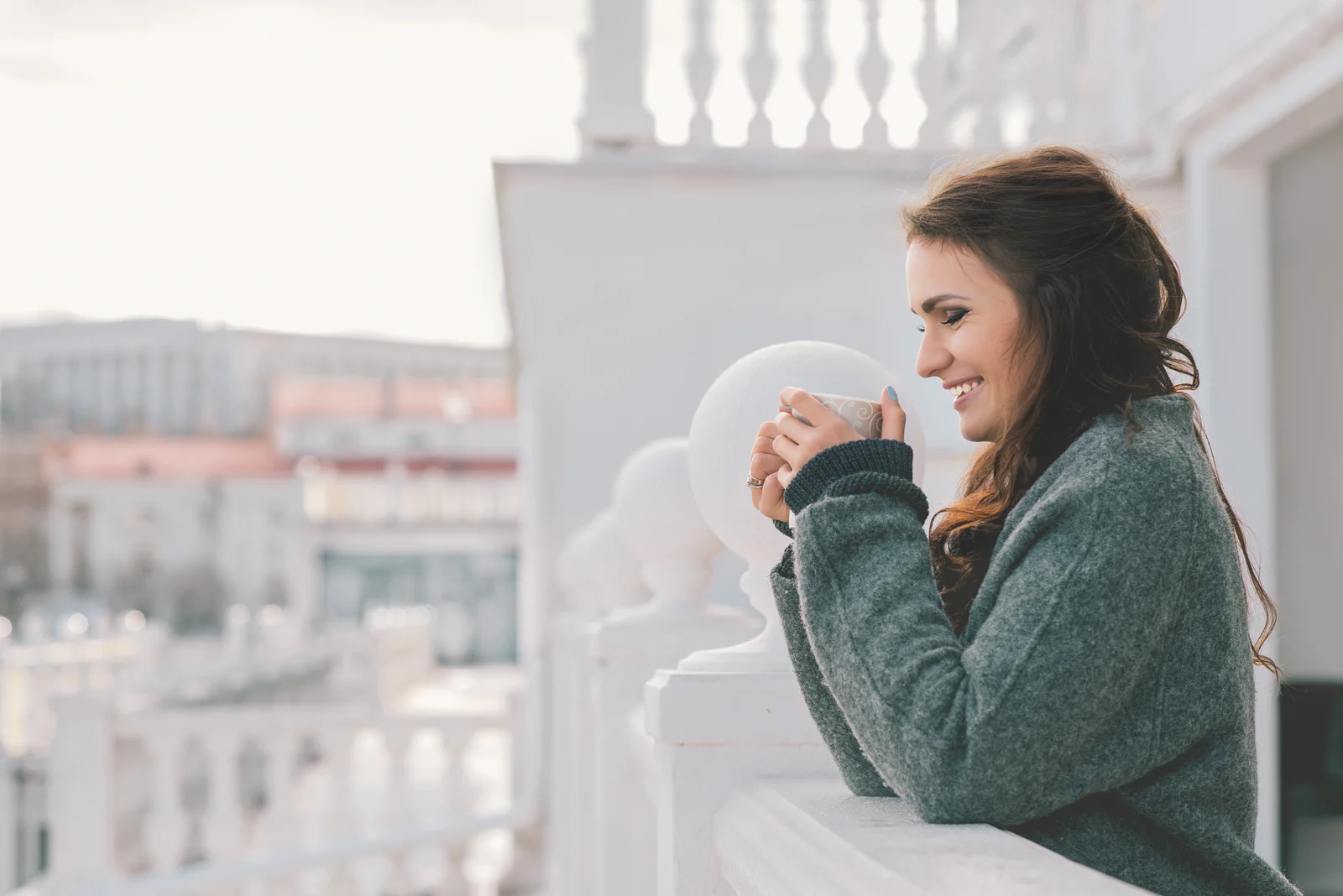 a smiling woman stands on the balcony with a salt shaker in her hand
