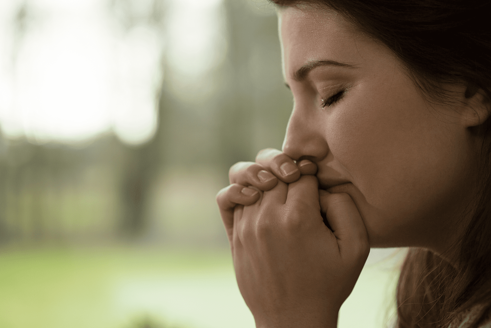 a woman with long black hair sits and cries