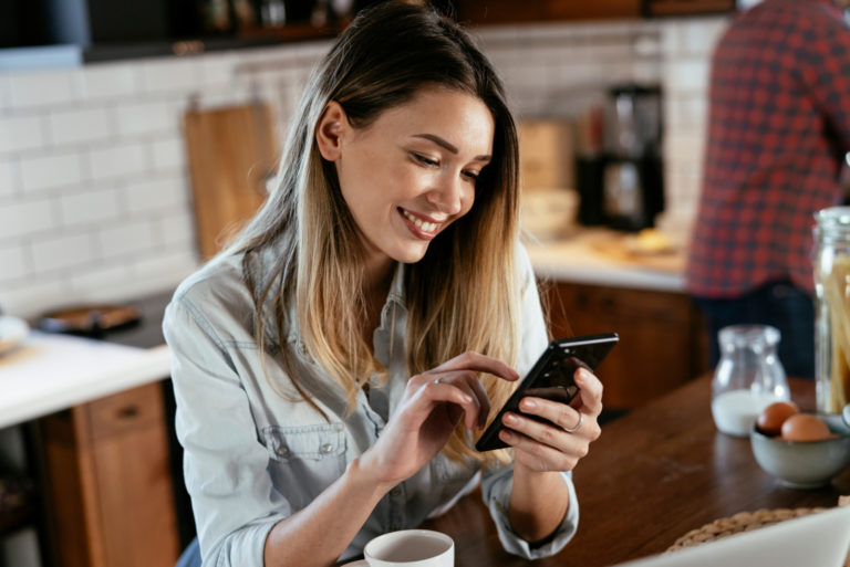 smiling woman texting on phone