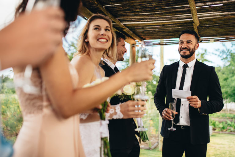 the woman gives a speech to the smiling newlyweds