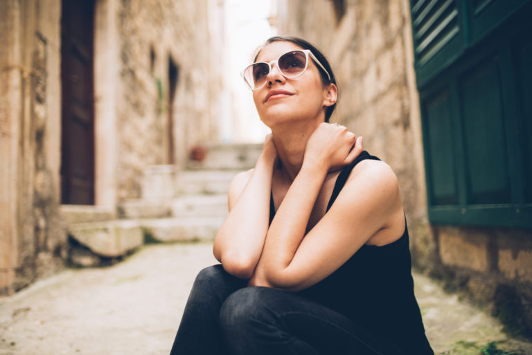 uma mulher imaginária com óculos senta-se nas escadas