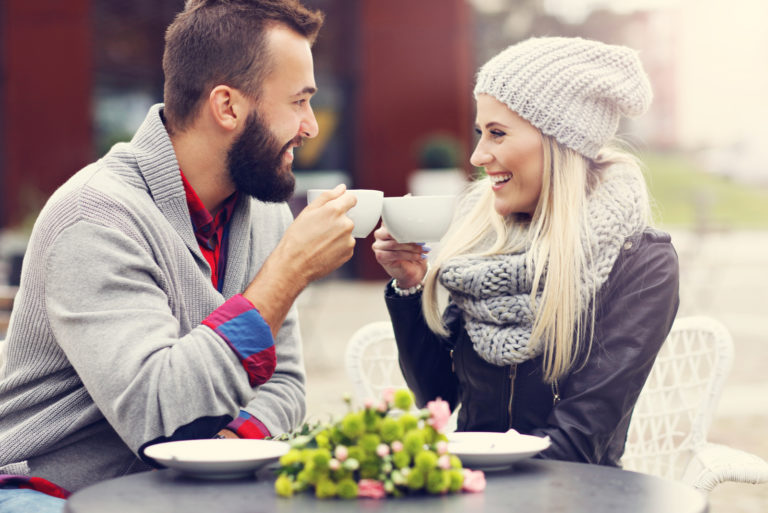 a smiling loving couple sitting outdoors