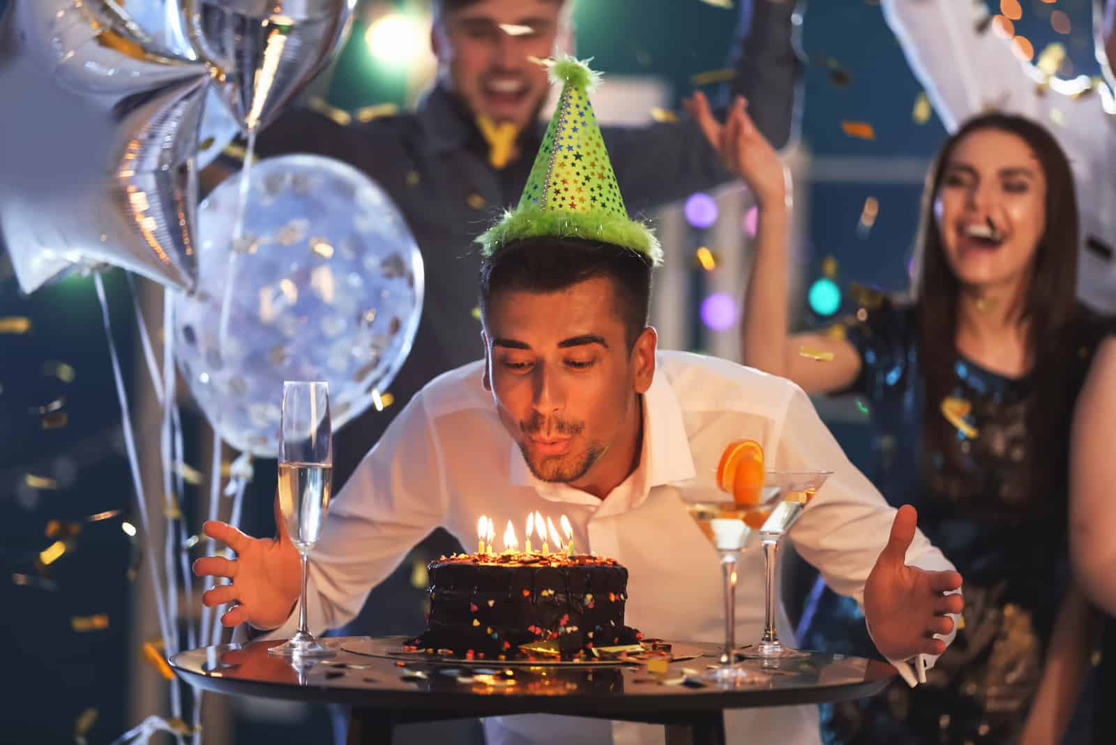a man blowing into a cake