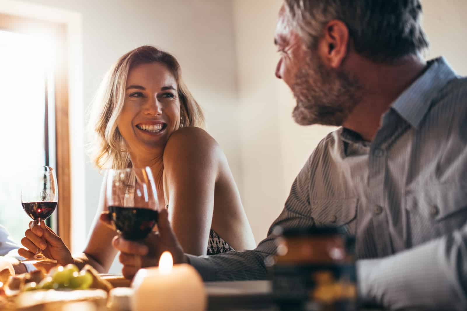 una coppia sorridente e innamorata che parla bevendo vino